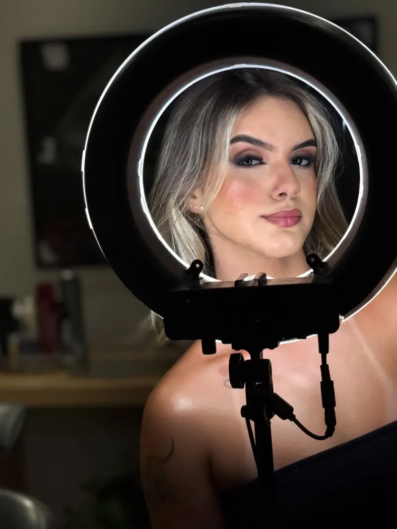 Cliente refletida no espelho com ring light durante o atendimento